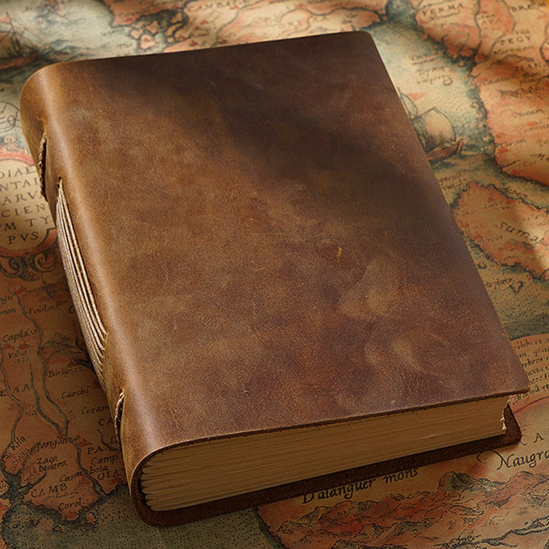 Brown leather-cover journal on a map used for styling