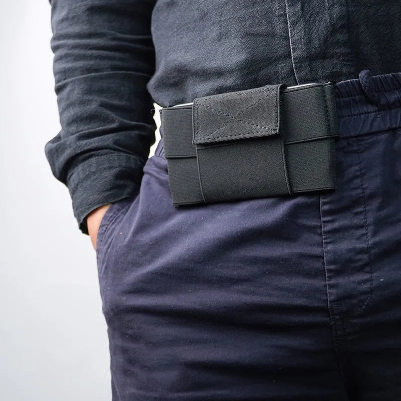 Black waist pouch with central cover worn at a waistband