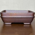 Brown rectangular stoneware planter on a wooden surface